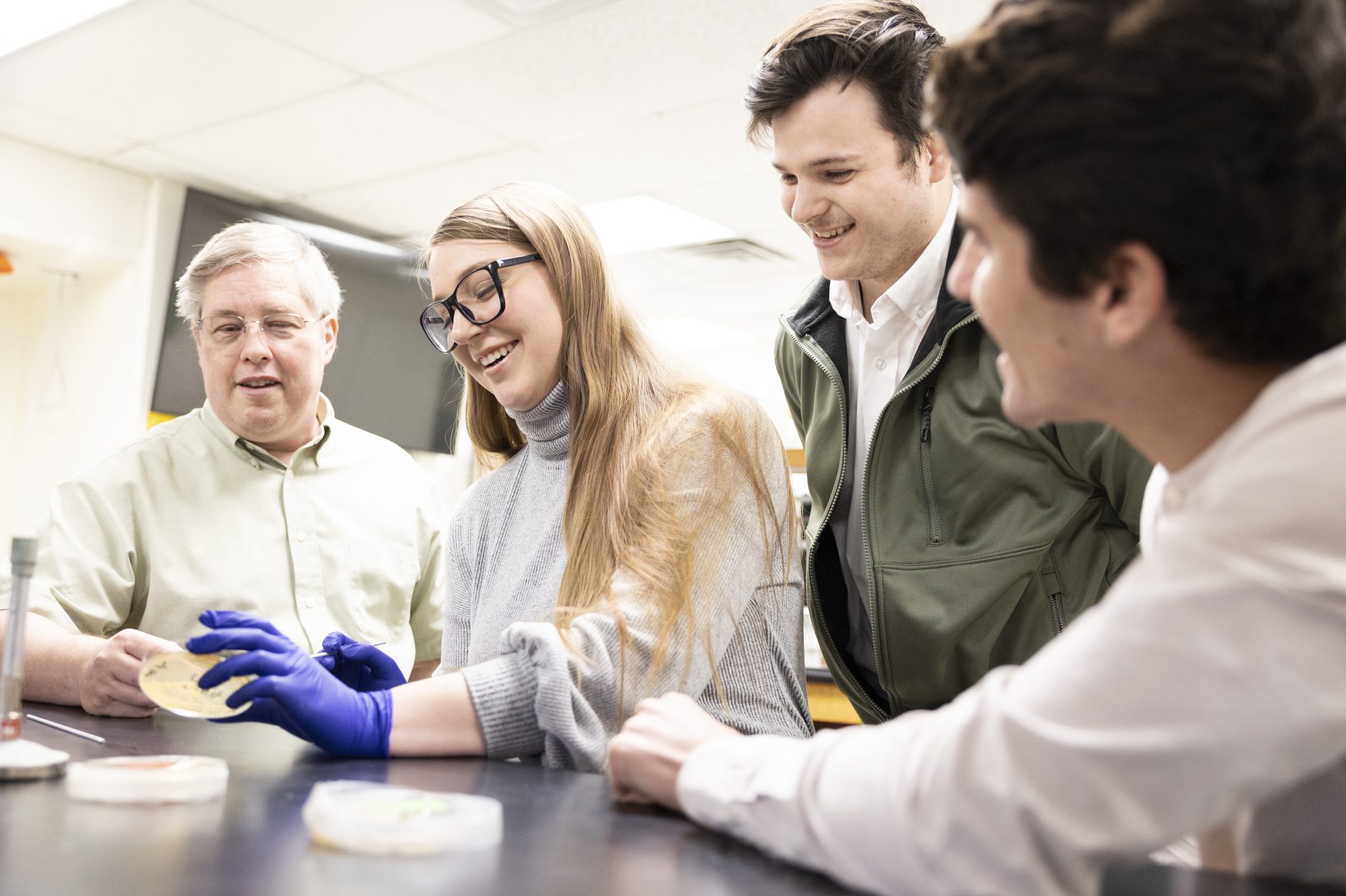 Students working in the biology lab with their professor.
